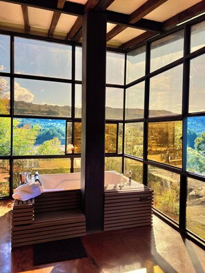 A room with large windows, a wooden bench, and a hot tub. - Private Cabin to Enjoy Luxury and Comfort (Rionegro)