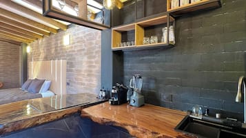 A modern kitchen with a marble countertop, wooden beams, and built-in shelves.