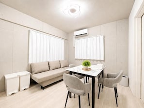 A modern living room with a sofa, dining table, and chairs. - SLEEPLAB Ikebukuro (Toshima City)