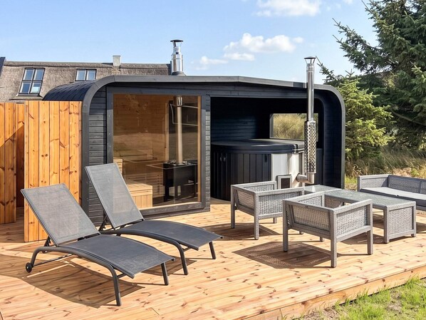 An outdoor deck with lounge chairs and a hot tub. - 6 Person Holiday Home in Blavand (Blavand)