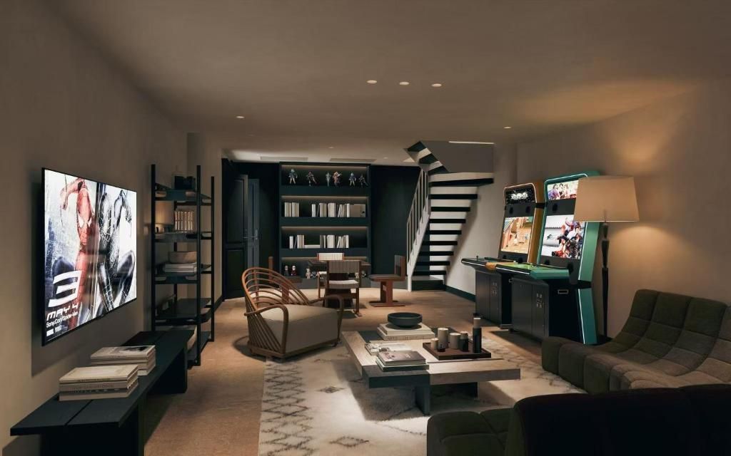 A modern living room with a flat-screen TV, bookshelves, a sofa, a coffee table, and a staircase.