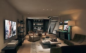 A modern living room with a flat-screen TV, bookshelves, a sofa, a coffee table, and a staircase. - ZMANOR Luxury Loft Near Jingan Temple (Shanghai)
