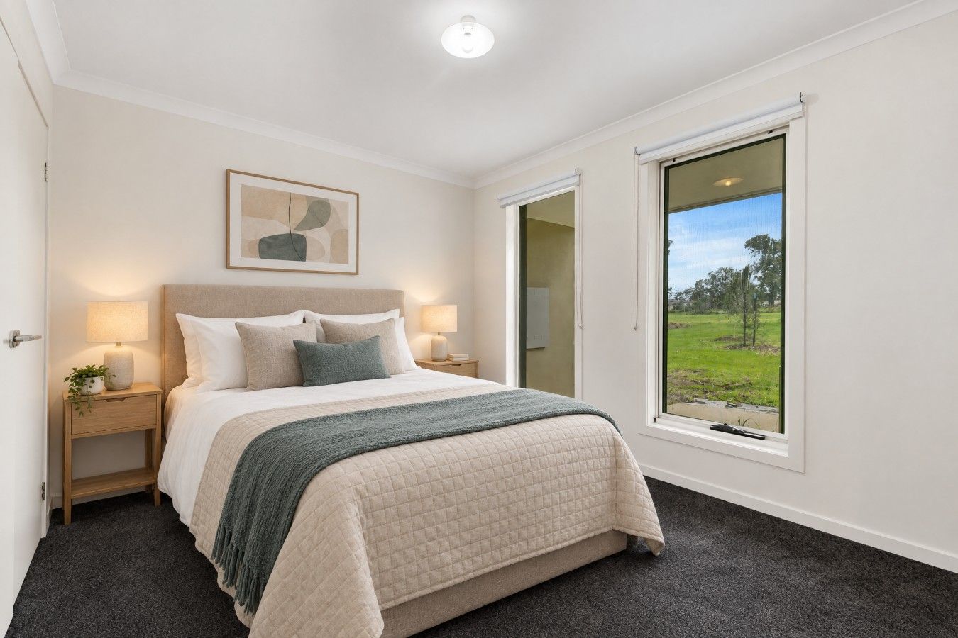 A bedroom with a bed, bedside tables, a window with a view, and a ceiling light.