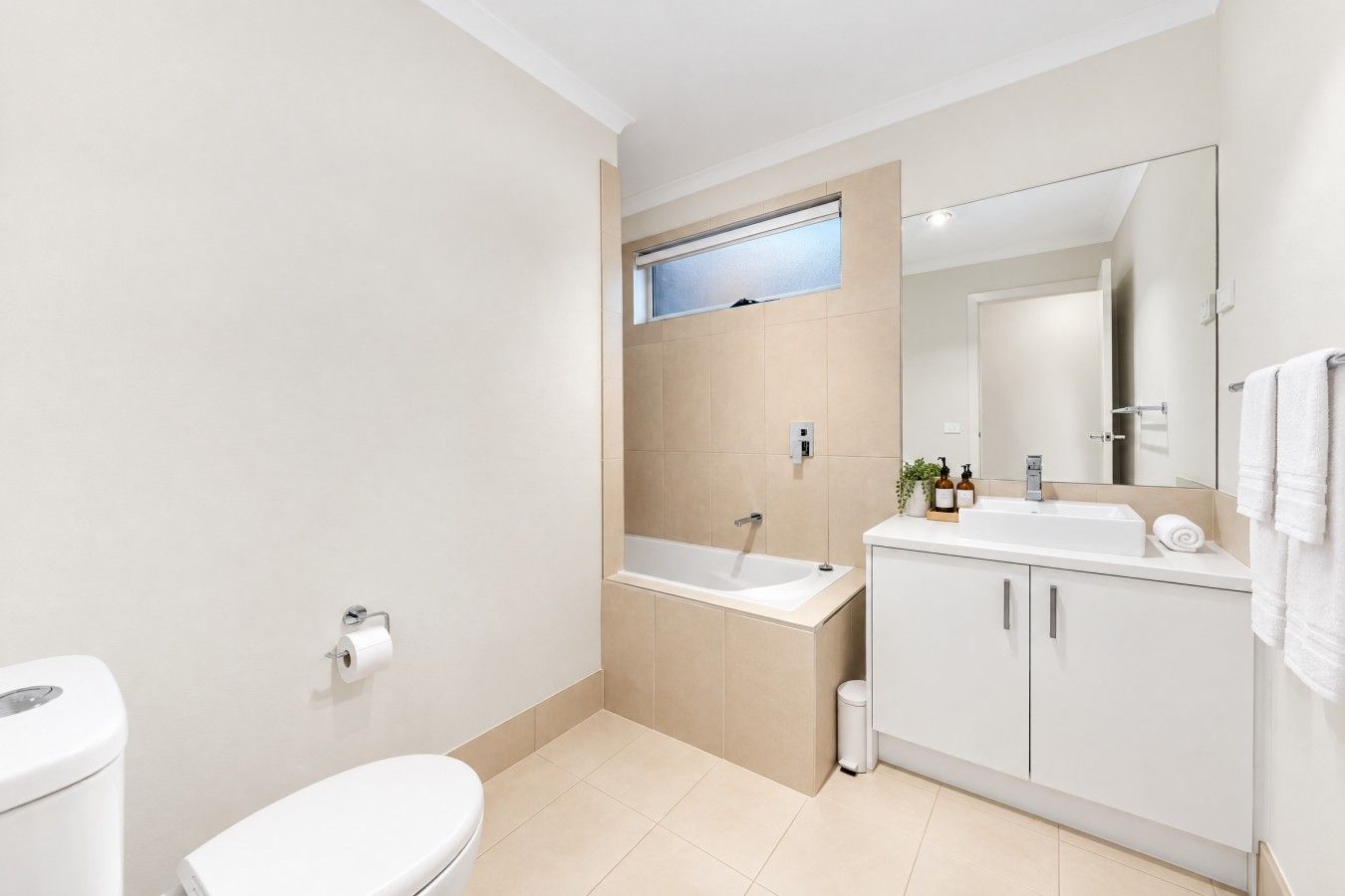 A modern bathroom with a toilet, sink, and bathtub.