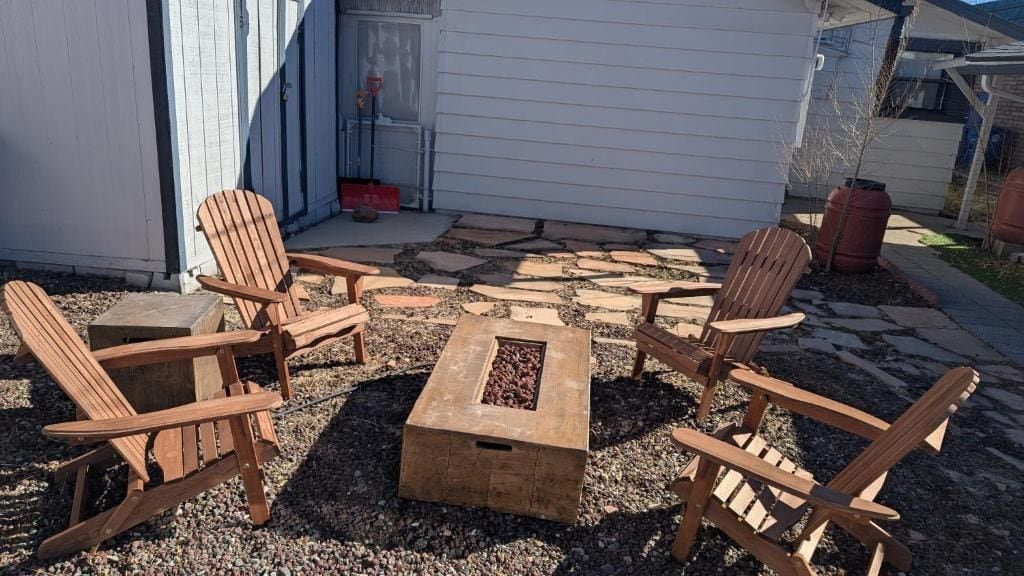 A patio with Adirondack chairs and a fire pit.