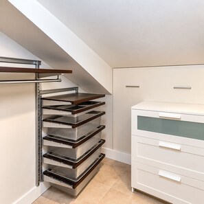 Eine Küche mit eingebautem Ofen, einem weißen Schrank mit Glastüren und einem Holzregal.