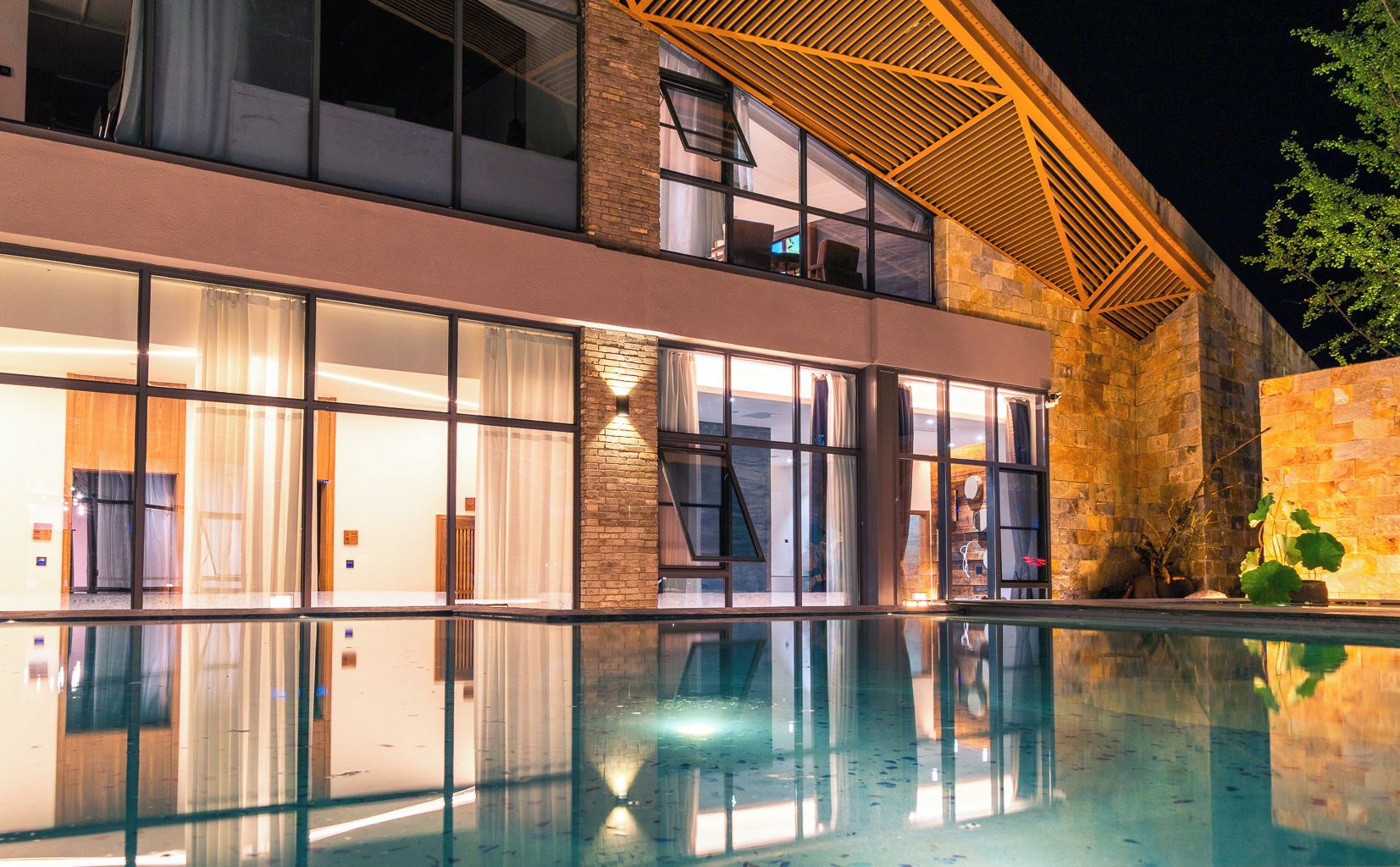 Un hotel moderno con piscina, ventanas amplias y fachada de ladrillo.