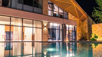 Un hotel moderno con piscina, ventanas amplias y fachada de ladrillo.