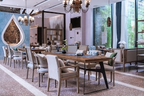 A spacious dining area with a long wooden table, multiple chairs, and a decorative wall feature.
