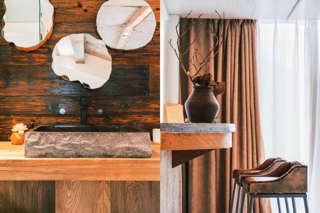 A wooden wall with a sink and a mirror. There is a vase with branches on a counter.