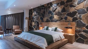 Une chambre à coucher moderne avec un mur en pierre, un cadre de lit en bois et une table de chevet avec une lampe.