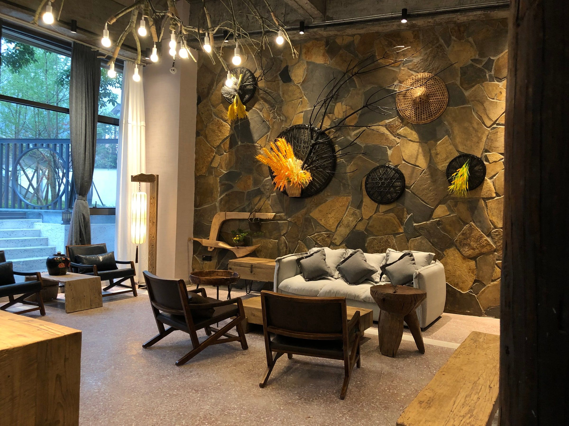 A cozy interior with a stone wall, wooden furniture, and decorative elements.