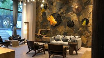 A cozy interior with a stone wall, wooden furniture, and decorative elements.