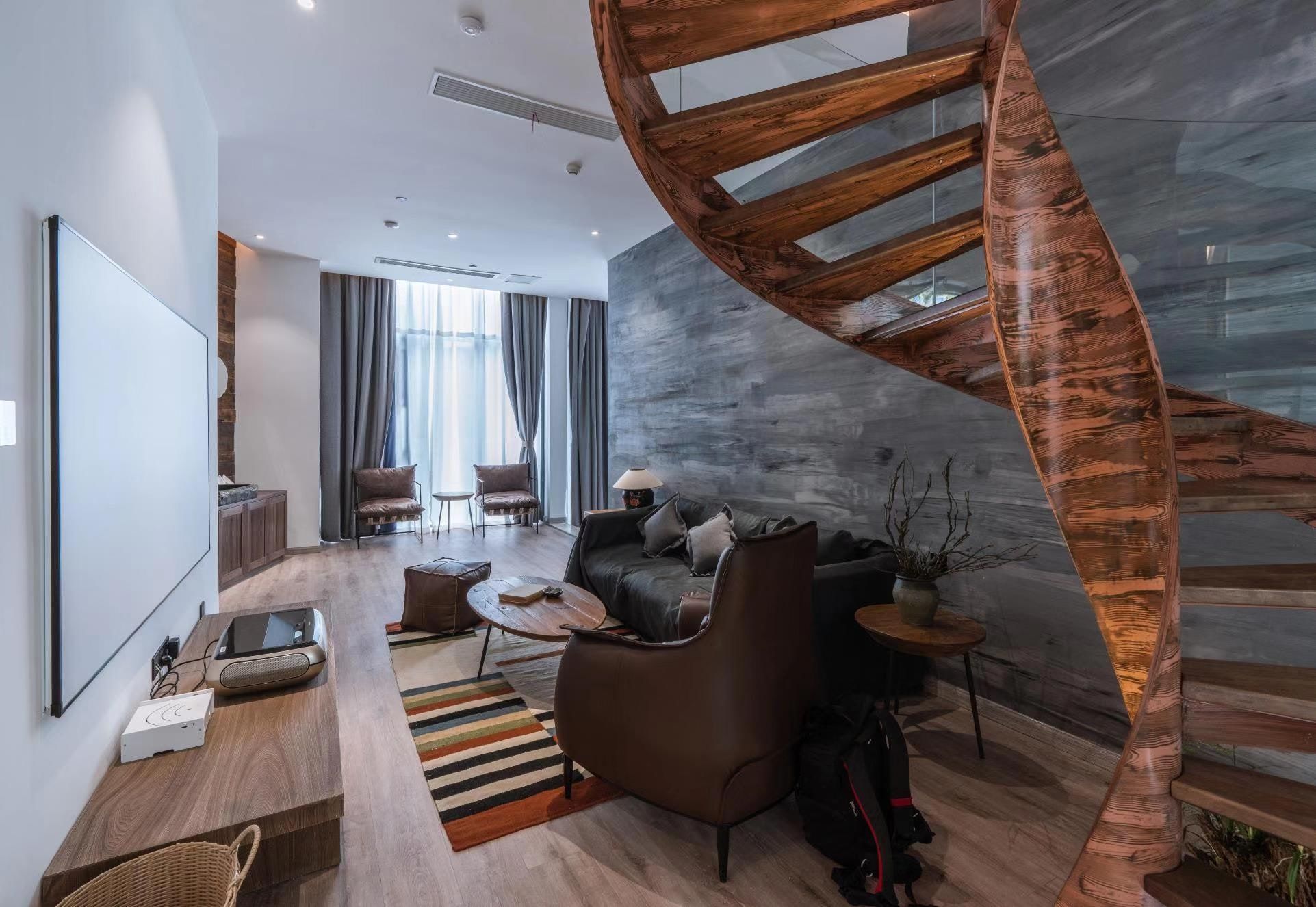 A modern living room with a spiral staircase, a sofa set, and a coffee table.