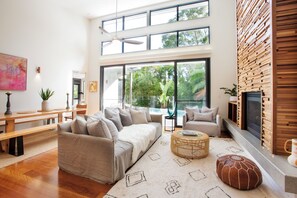 Ein modernes Wohnzimmer mit einer Couch, einem Hocker und einem Kamin.