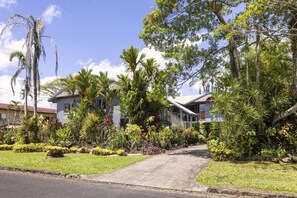 A residential property with a paved driveway leading to a house with a sloped roof and a covered porch. - Peaceful 2-Bedroom in Innisfail Cassowary Coast (Belvedere)