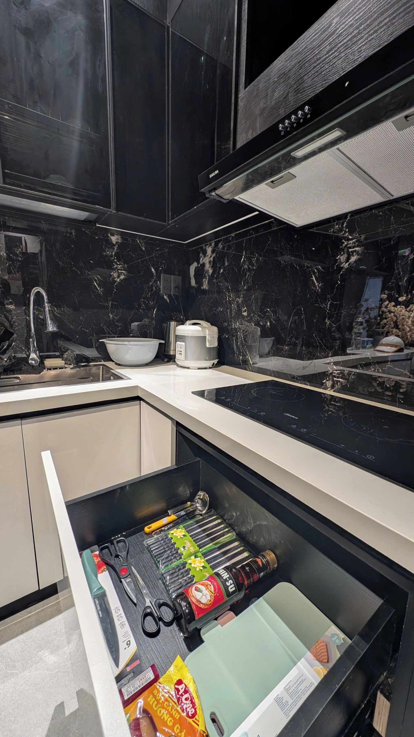 A modern kitchen with a built-in dishwasher, a microwave, and a stainless steel sink.