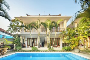 A two-story building with a swimming pool in the foreground.