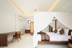 A bedroom with a canopy bed, a wooden desk, and a rattan chair.