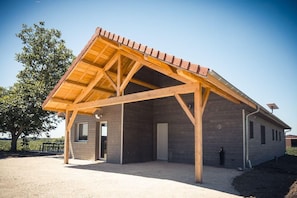 A building with a wooden structure and a sloped roof. - Au Bout du Chemin Ecolodge (GERAUDOT)