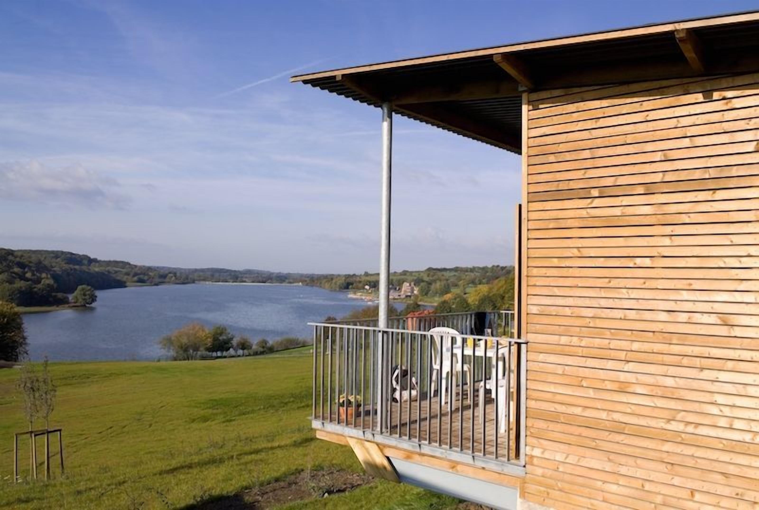 Un bâtiment en bois doté d’un balcon donnant sur un lac.