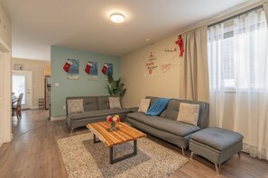 A living room with a grey sofa, a wooden coffee table, and Christmas decorations. - Spacious , luxurious home for comfort, privacy and convenience. Great for Aurora (Yellowknife)