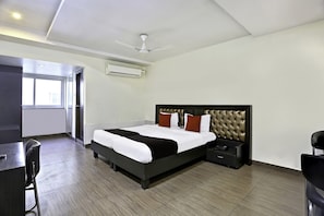 Ein modernes Hotelzimmer mit einem großen Bett, einem Schreibtisch und einem Stuhl.
