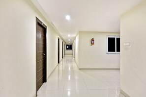 A long, narrow hallway with doors on one side and a window on the other. - Hotel O Madhapur Hyderabad  (Hyderabad)