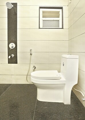 A bathroom with a toilet, a shower, and a window. - Hotel O Madhapur Hyderabad  (Hyderabad)