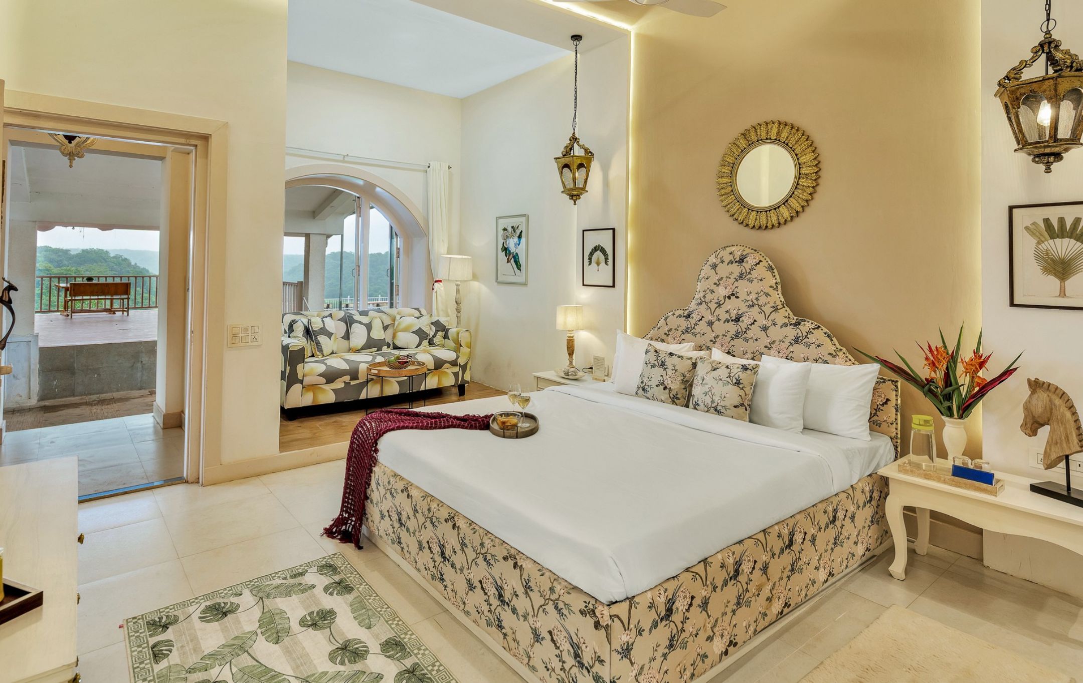 Un dormitorio con una cama grande, un sofá, una mesa de comedor y vistas al exterior.