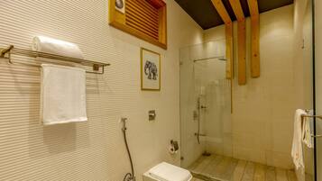 Un baño con ducha, inodoro y toallero.