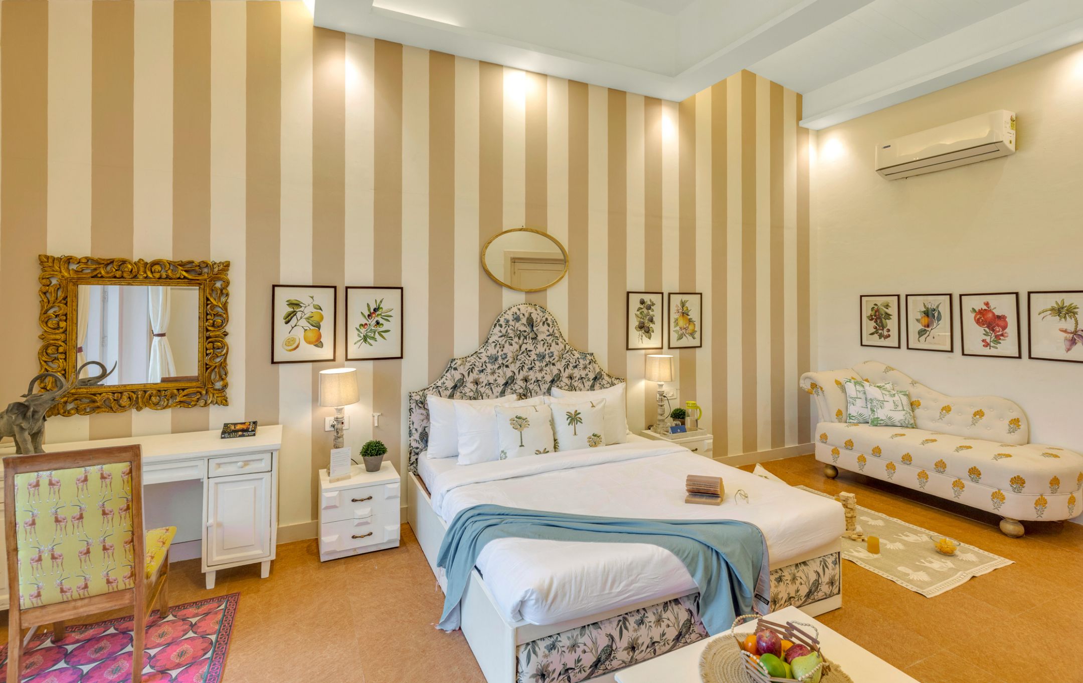 Een slaapkamer met een bed, nachtkastjes, een dressoir, een spiegel en een sofa.