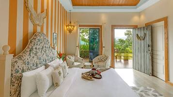Un dormitorio con una cama grande, dos sillas, un balcón con vistas y un techo de madera.