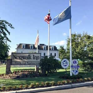 Placa do Norwalk Inn com uma bandeira americana e uma bandeira com design azul e branco.