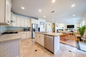 A modern kitchen with white cabinetry, stainless steel appliances, and a central island. - 19ppl 6b4b Perfect for Big Group Garage Parking (Monterey Park)