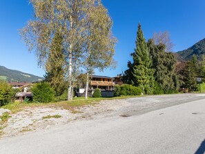 Ein Gebäude mit Holzfassade, Steinfundament und erkennbarem Eingang.