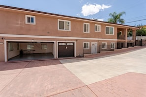 A multi-story building with a garage on the ground floor, a covered patio, and a clear sky. - 22ppl 7b5b Perfect family&biz stay Garage Gated (Monterey Park)