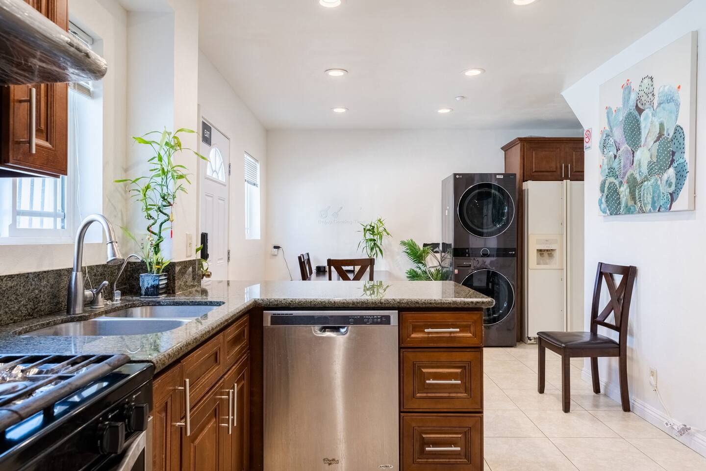 A modern kitchen with granite countertops, stainless steel appliances, and wooden cabinetry.