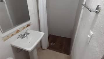 Een badkamer met toilet, wastafel en douche.
