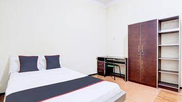 A bedroom with a bed, a desk, and a wardrobe.