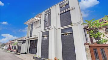 A modern two-story building with a flat roof, large windows, and a gated entrance.