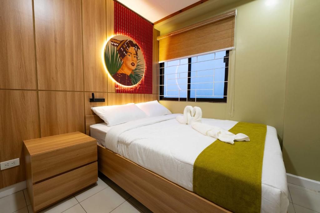 A modern bedroom with a bed, wooden nightstand, and a wall-mounted artwork.