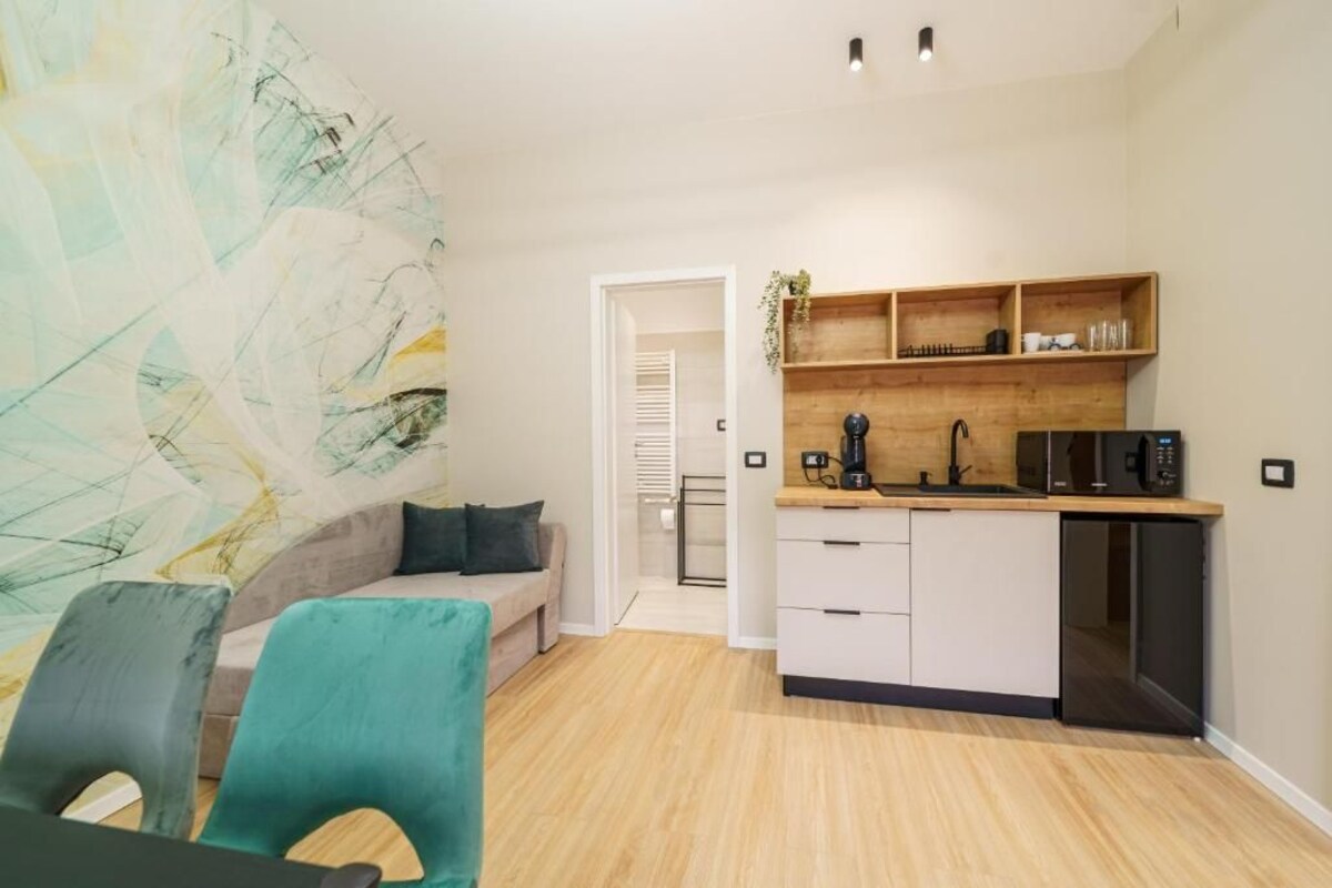 Um espaço compacto com cozinha compacta, sofá e área de refeições.