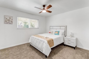 A bedroom with a bed, a nightstand, a ceiling fan, a window with blinds, and a wall-mounted artwork. - Spacious 4-bedroom house in lovely Carmichael (Carmichael)