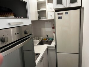 A compact kitchen with a built-in oven, a sink, and a refrigerator. - Perfect 1-bedroom apartment with AC in fabulous Beograd (Beograd)