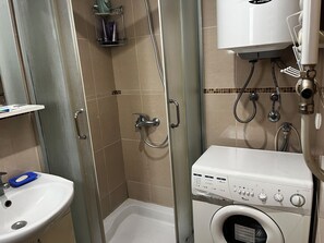 A bathroom with a sink, shower, and a washing machine. - Perfect 1-bedroom apartment with AC in fabulous Beograd (Beograd)