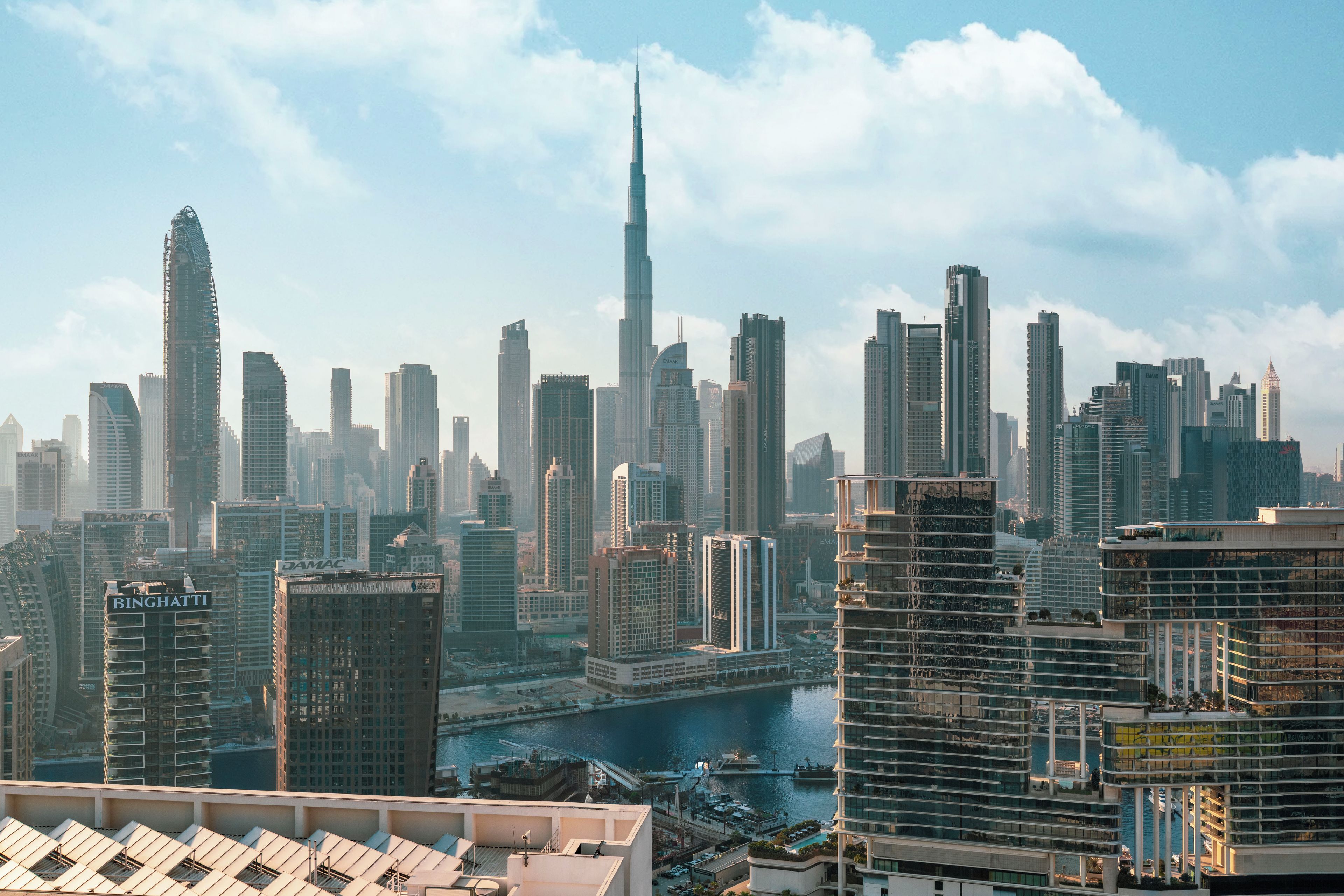 A cityscape with modern high-rise buildings, including a prominent skyscraper.