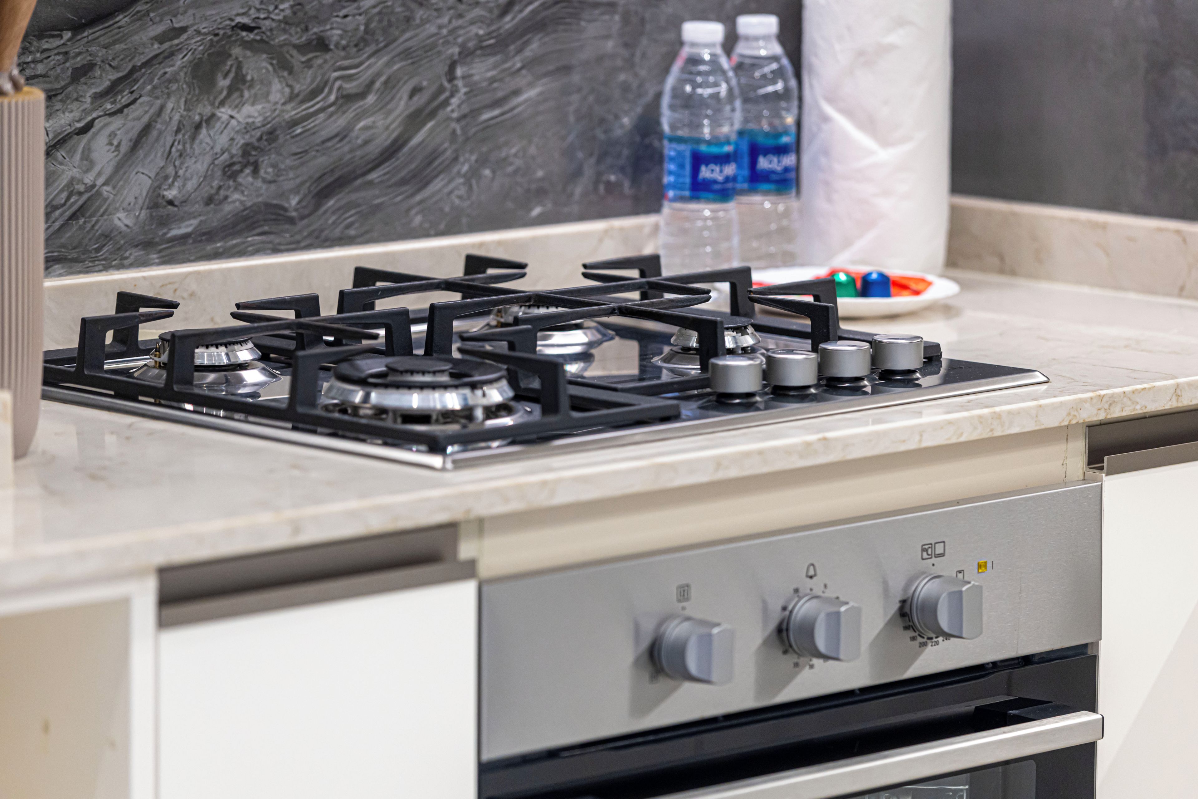 A kitchen with a gas stove, a sink, and a countertop.