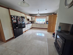 A kitchen with a refrigerator, stove, and cabinets.