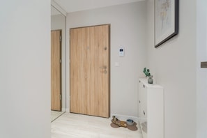 Ein Korridor mit einer Holztür, einem weißen Schrank und einem gerahmten Bild an der Wand.